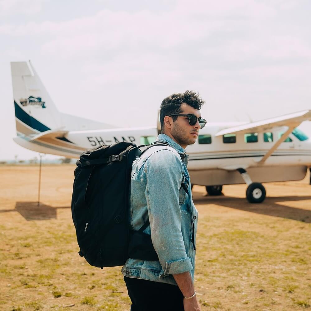 Good looking man wearing his black backpack and ready to flight