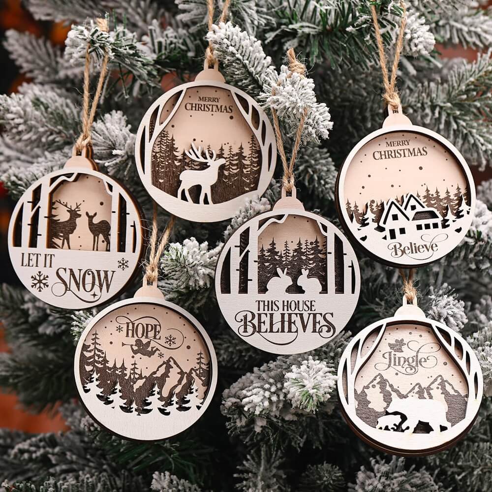 A set of six wooden gifts as Christmas ornaments with various winter scenes and messages, including "Merry Christmas," "Let It Snow," "This House Believes," "Hope," and "Jingle"