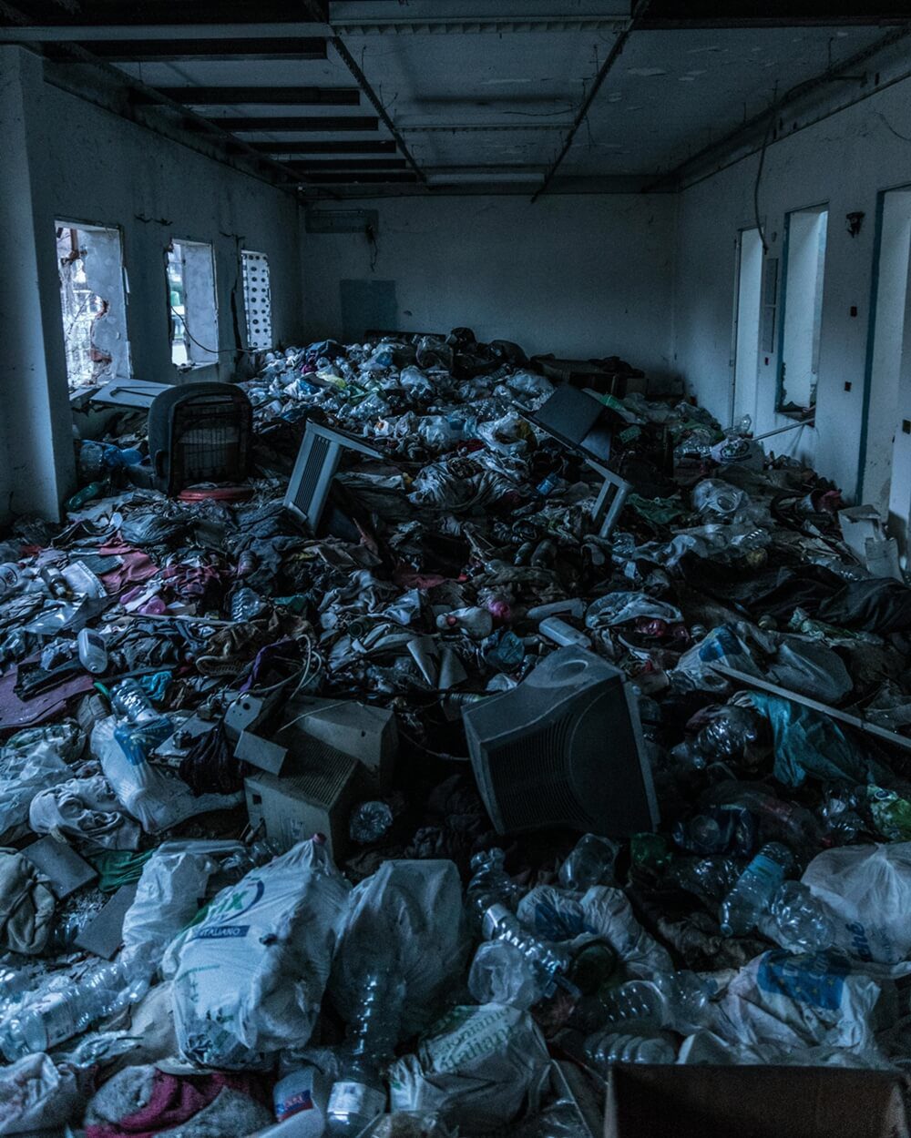 A room filled with discarded electronic waste and other debris, highlighting the urgent need to reduce plastic pollution