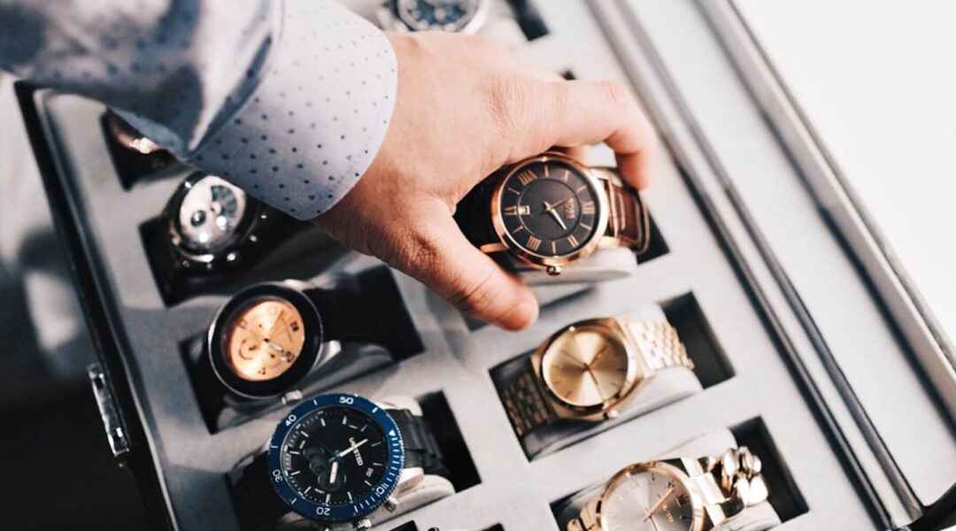 A watch collector carefully selecting a timepiece from a variety of styles and colors