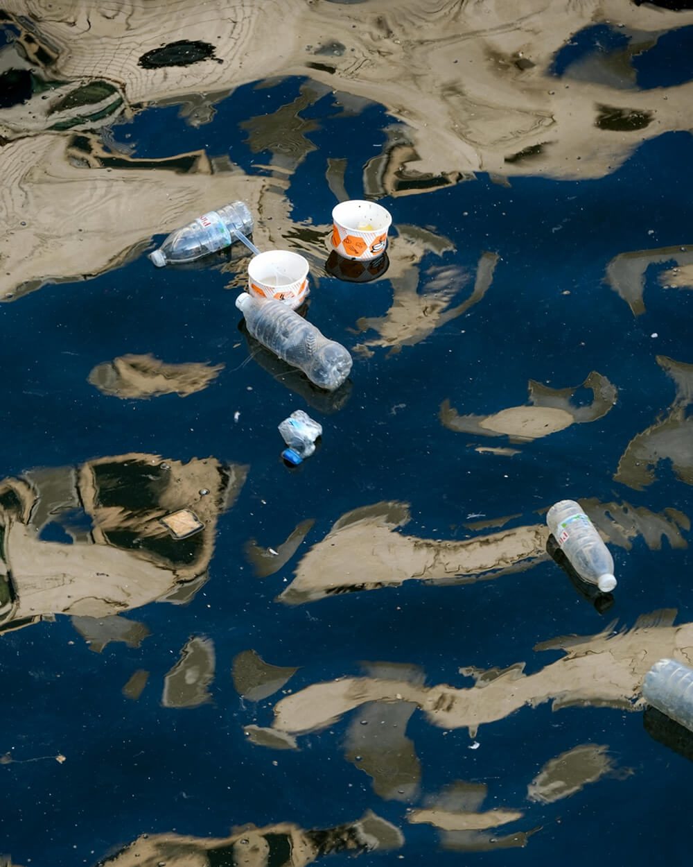 Plastic waste floating on the surface of a body of water, highlighting the issue of plastic pollution